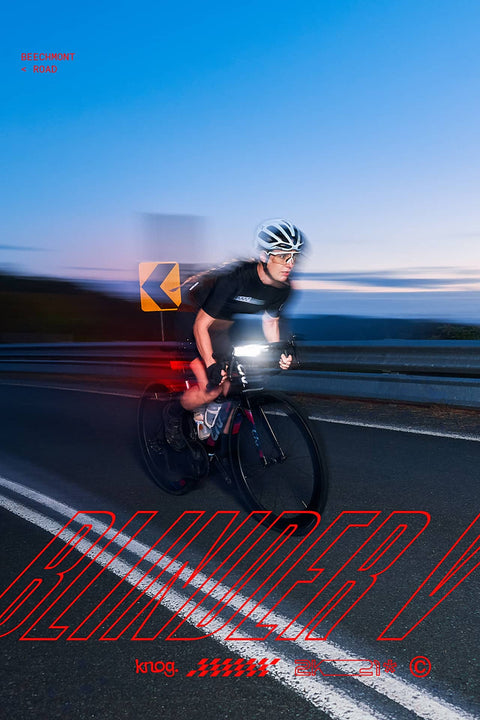 **Alt-Text (German):**
Radfahrer mit Knog Blinder Licht bei Nacht auf kurviger Bergstraße.