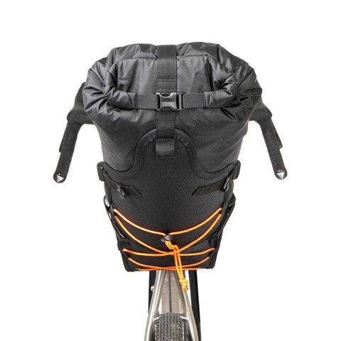 Fahrrad mit schwarzer Lenkertasche und orangefarbenem Spanngurt, montiert am Lenker für Bikepacking oder Radtouren.