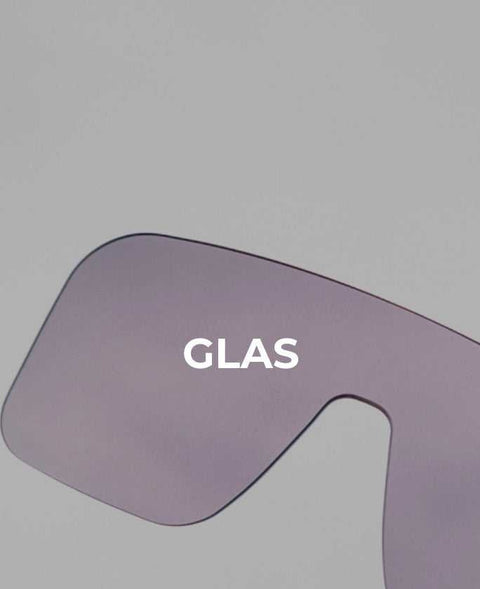 Teil einer modernen, getönten Sonnenbrille mit großflächigem Glas in lila Farbton auf grauem Hintergrund, minimalistisch gestaltet.