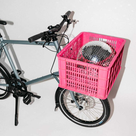Compact Cargobike Flinc mit pinker Kiste und Discokugel. Stylisches Mietrad für kreative urbane Transporte.