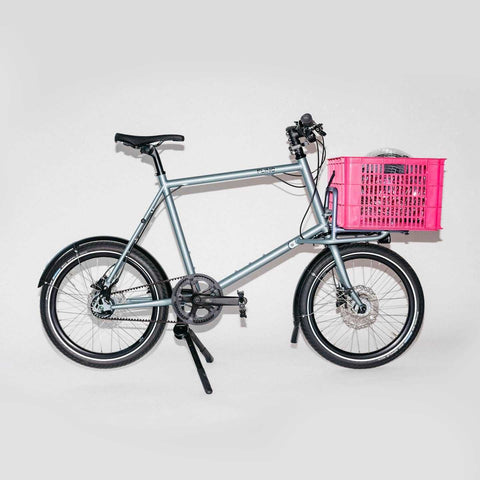Miete das Compact Cargobike Flinc mit pinker Transportkiste vorne. Perfekt für Stadtfahrten mit zusätzlichem Stauraum.