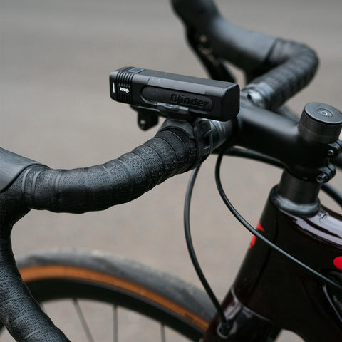 Knog Blinder Frontlicht an Rennradlenker befestigt, ideal für sportliche Touren. Kompaktes Lichtset für maximale Sichtbarkeit bei Dunkelheit.