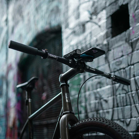 Knog Blinder Frontlicht am Fahrradlenker in urbaner Umgebung montiert. Teil des Knog Blinder Front & Rücklicht Sets für Stadtfahrten.
