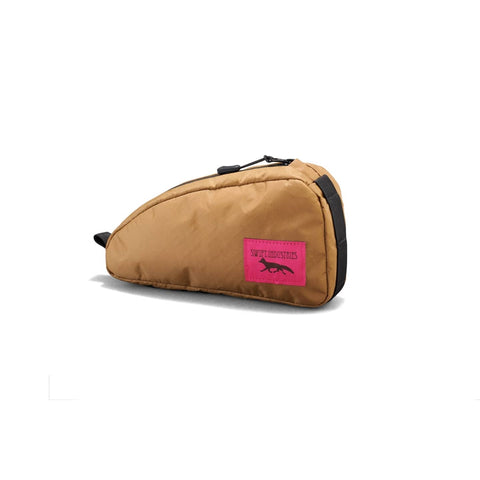 Swift Industries Moxie Top Tube Bag 0.6L in Braun mit pinkem Logo, ideal für Abenteuerfahrten mit der Kestrel Handlebar Bag 2L kombinierbar.