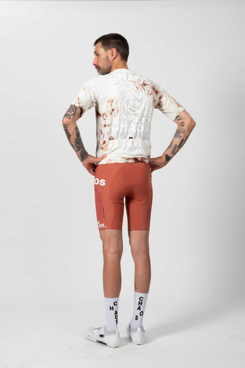 Männlicher Radfahrer trägt ein weißes Performance Cycling Jersey mit braunen Akzenten, reflektierenden Details, enger Passform, auf weißem Hintergrund