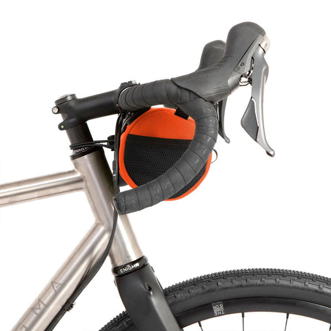 Seitenansicht der orangefarbenen Restrap Canister Bag, kompakt am Lenker befestigt, ideal für Gravelbikes.
