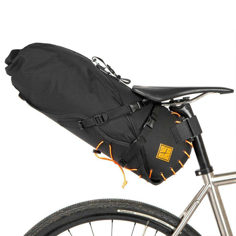 Restrap Satteltasche 18l/14l mit orangefarbener Schnürung, robust befestigt für sicheres Bikepacking.