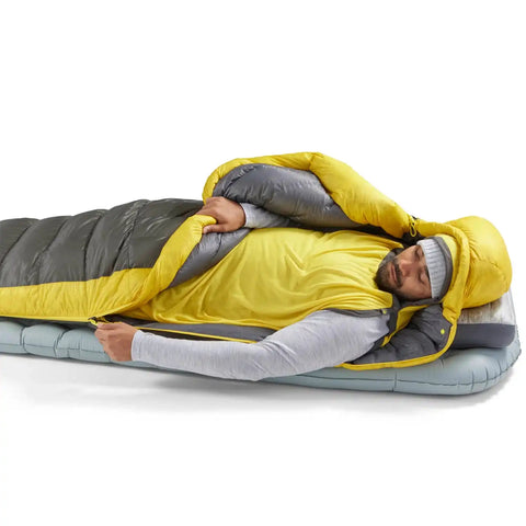 Person öffnet Sea to Summit Spark Daunenschlafsack Unisex im Zelt, ideal für komfortables Schlafen beim Trekking.