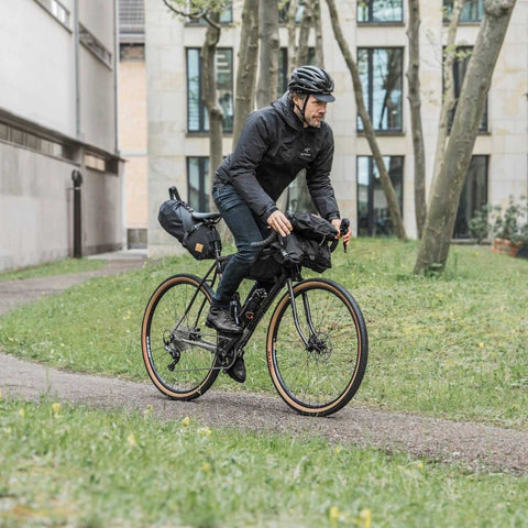 Schwarzes Gravel-Bike mit Gepäckträger, Fahrradkoffer und Satteltaschen, für Bikepacking, L-Größe, urbanes Umfeld, robustes Design