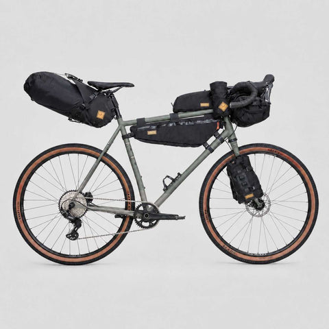 Graues Gravel-Bike mit schwarzen Packtaschen, Rahmen in Grau, für Bikepacking, 188-196cm, mit Zubehör für Outdoor-Abenteuer