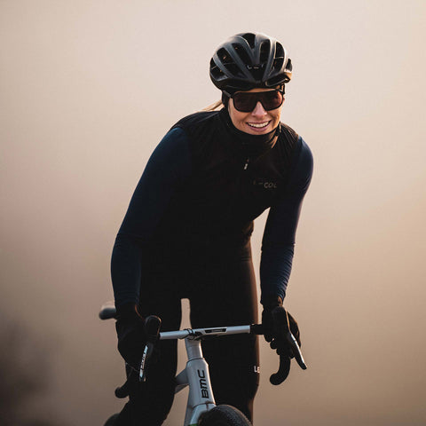 Radfahrerin mit Ileve No. 1 Cycling Sunglasses und Helm bei Sonnenaufgang, stylisches Accessoire für Performance und Komfort.
