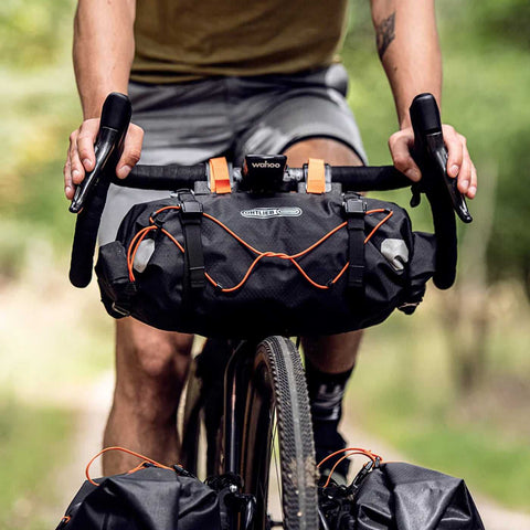 Ortlieb Handlebar-Pack in Schwarz mit orangefarbenen Details am Gravelbike montiert, perfekt für lange Touren.