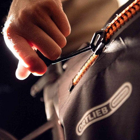 Detailaufnahme der Ortlieb Bike Frame Bag 4L mit orangefarbenem Reißverschluss, zeigt einfache Handhabung und hochwertige Verarbeitung für Outdoor-Abenteuer.