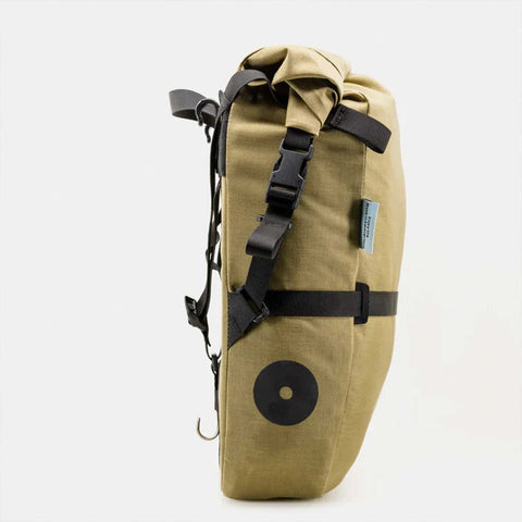 Nahaufnahme der beige Fahrrad-Gepäcktasche mit schwarzem Tragegurt, Befestigungssystem und Logo-Label, für Outdoor-Touren