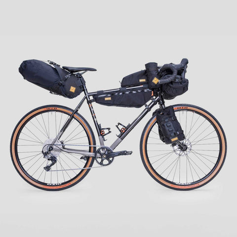 Gravelbike mit kompletter Bikepacking-Ausrüstung, inklusive Rahmentasche, Lenkertasche, Satteltasche und Gabeltaschen, ideal für lange Touren und Abenteuerfahrten.