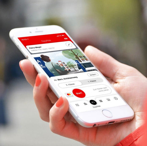 Person hält ein Smartphone mit geöffneter SBB Mobile App, zeigt Reisedetails und Ticketinformationen für eine Zugfahrt in der Schweiz.