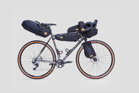 Gravelbike mit kompletter Bikepacking-Ausrüstung, inklusive Rahmentasche, Lenkertasche, Satteltasche und Gabeltaschen, ideal für lange Touren und Abenteuerfahrten.